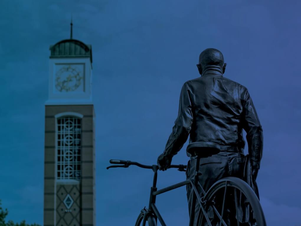 Statue of Bill Seidman 'looking' at the clock tower, with a blue overlay